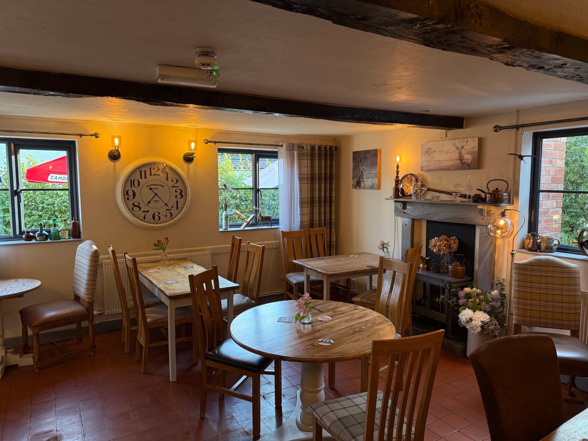 A light, informal dining room with a large wall clock and views to the garden